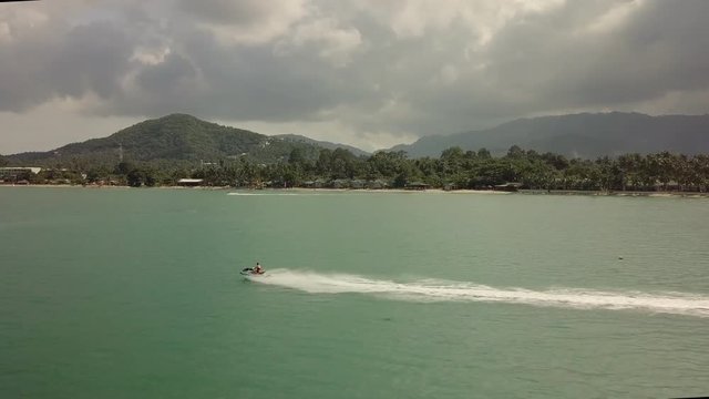 Water Jet scooter racing along beach kom samui beach