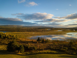 Aerial landscape view of a beautiful river during a sunny sunrise. Taken in Codroy Valley, Newfoundland, Canada.