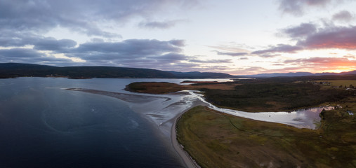 Aerial panoramic view of a beach on the Atlantic Ocean Coast during a dramatic sunrise. Taken in Codroy Valley, Newfoundland, Canada.
