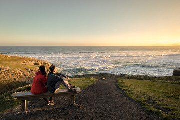 Couple enjoys beautiful coastal scenery near Dunedin in New Zealand. Romantic couple goes on...