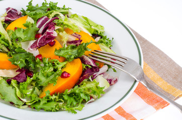 Salad with green leaves and persimmon