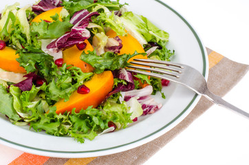 Salad with green leaves and persimmon