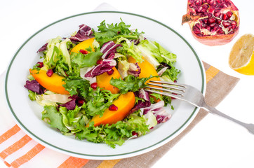 Salad with green leaves and persimmon