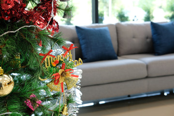 decorated christmas tree & sofa couch in living room. xmas holiday celebration in december