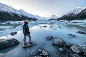 Foto auf Acrylglas Aoraki/Mount Cook Person, die auf Eissee und Schneebergen am Tasman Lake, Aoraki Mount Cook National Park, Neuseeland, steht.