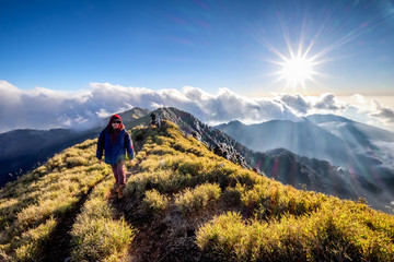 A breathtaking landscape in Taiwan. This was taken on top of a mountain. The clouds formation is vast and dramatic. The sun rises above the thick clouds. The image is calm, peaceful and magnificent. - obrazy, fototapety, plakaty