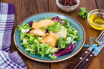 Concept of healthy food. Salad with green leaves and boiled salmon
