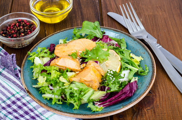 Concept of healthy food. Salad with green leaves and boiled salmon