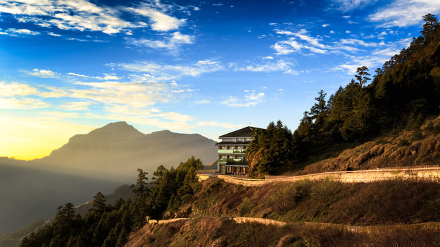 A house located high up on the slope of a mountain valley in Taiwan. Hehuanshan is a popular destination for the local people, tourists, and adventurers. The sunshine provides warmth to the area.