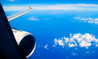 This is an aircraft wing view. The sky is deep and blue. There are amazing blue ocean below. It is very suitable for background use.