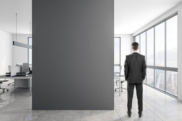 Fototapeta premium Young businessman in concrete office