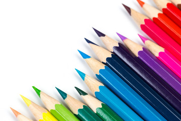Colour pencils on white background, top view.
