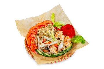 Wicker plate of traditional vietnamese dish - egg noodles with seafood, shrimps and vegetables isolated at white background.