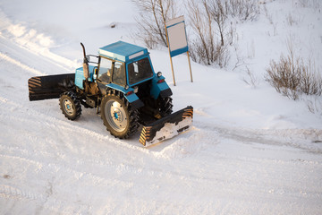 tractor cleans snow