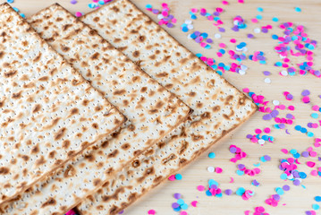 Pesach celebration concept. Matzah and confetti happy colorful background for Jewish Passover holiday.