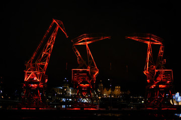 Highlighted cranes in Szczecin, a city monument. Highlighted cranes in Szczecin, a city monument. - obrazy, fototapety, plakaty
