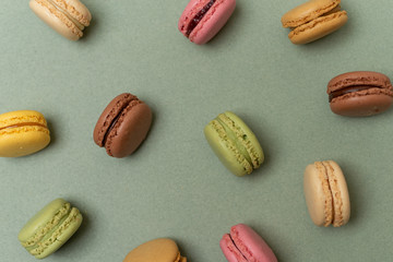 Cake macaroons or macaroons on green background from above