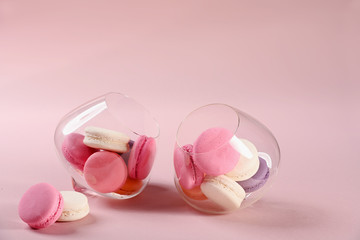 Two glasses with French pink macaroons on a pink background. Gift for Valentine's day. Ideal for holiday of international women's day.