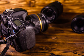 Modern dslr camera and lenses on wooden table