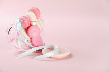 Pink macaroons in glass cup on a pink background. Gift for Valentine's day. Ideal for holiday of international women's day.