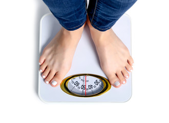 Female feet weighing scale on a white background isolation, top view