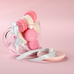 Pink macaroons in glass cup on a pink background. Gift for Valentine's day. Ideal for holiday of international women's day.