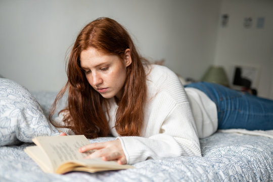 Young woman reading on bed