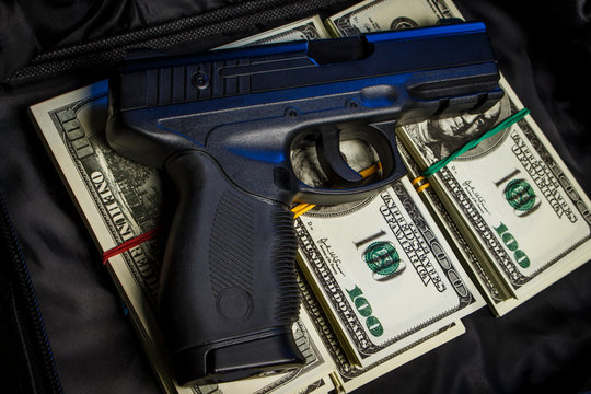 Bundle of dollars with a gun in a black bag