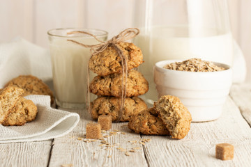 Oatmeal cookies with milk on tray on rustic wooden table