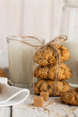 Oatmeal cookies with milk on tray on rustic wooden table