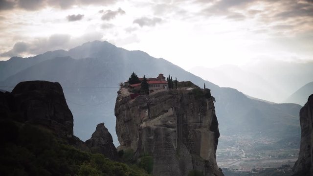 Clouds and sunshine over holy Trinity monastery on cliff in Meteora, Thessaly Greece. Greek destinations. Time lapse