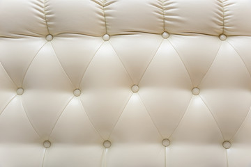 Concept yellow white buttoned luxury pattern. Capitone eco-leather background. Chesterfield style, checkered soft fabric furniture upholstery, diamond pattern, decoration with buttons, close up