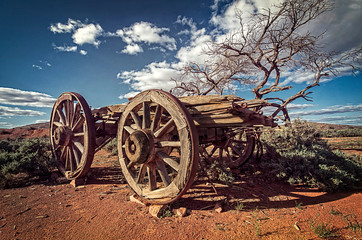 Fototapeta na wymiar Australia – Outback savanna with an old vintage derelict horse-drawn carriage at the bush under blue sky