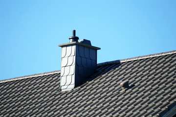 Neu gedecktes Dach mit aus schieferverkleidetem Kamin