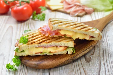 Tuinposter Geroosterde en getoaste panini met ham, kaas, tomaten en sla, geperst in de contactgrill © kab-vision