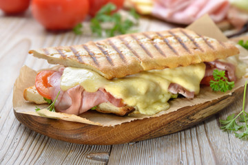 Getoastetes und im Kontaktgrill gepresstes italienisches Panini mit Schinken, Käse , Tomaten und Salat  - Pressed and toasted panini with ham, cheese, tomatoes and lettuce 