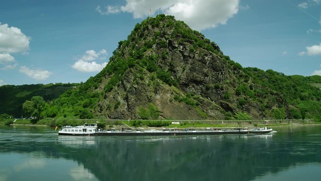 Cargo ship. Loreley Rock at the Rhine River  with the City St. Goar in the background, region Rhineland-Palatinate, Germany St. Goar, Central Europe, july 2017