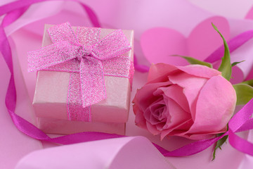 Pink rose and a gift box with hearts, valentine day background