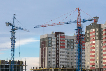 Fototapeta na wymiar two cranes building a house