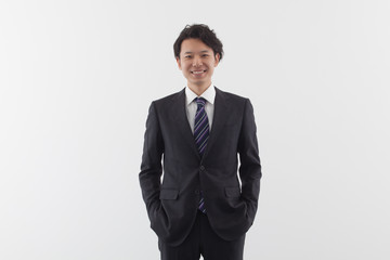 A young Asian business man standing with smile