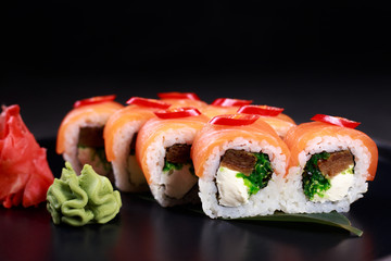 Japanese restaurant menu photo, seafood, national cuisine. Delicious sushi. Appetizing rolls served on black  plate, close up