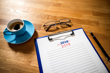 Plans 2019 versus 2018 on wooden board, flat lay