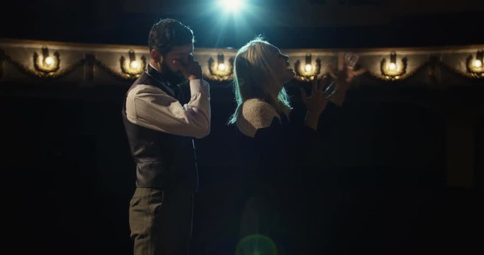 Medium shot of an actor and an actress rehearsing an intense scene in a theater