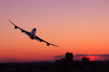 Airplane flying over city with skyscrapers at night. Turn right.