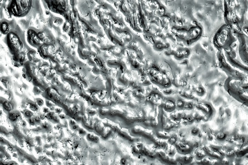 Molten metallic silver texture background in closeup