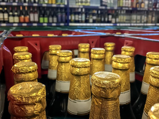 View into a beer crate standing in a beverage market. Crate with full beer bottles. Focus on the bottles. Concept: drinks