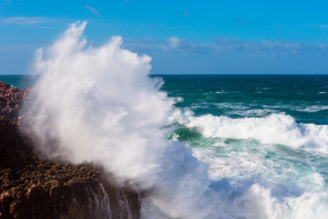 Sea waves hitting rocks cliff at Praia Da Bordeira, Portugal