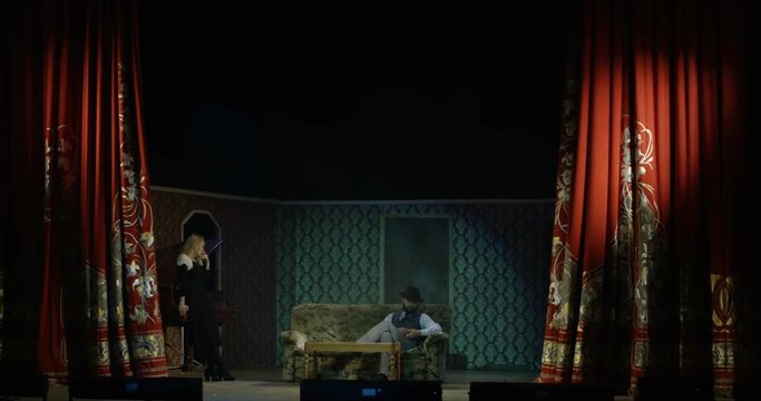 Full shot of actors and actresses rehearsing a scene in a theater