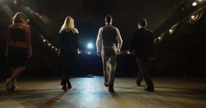 Slow motion of actors and actresses walking on the stage and bowing to audience in a theater
