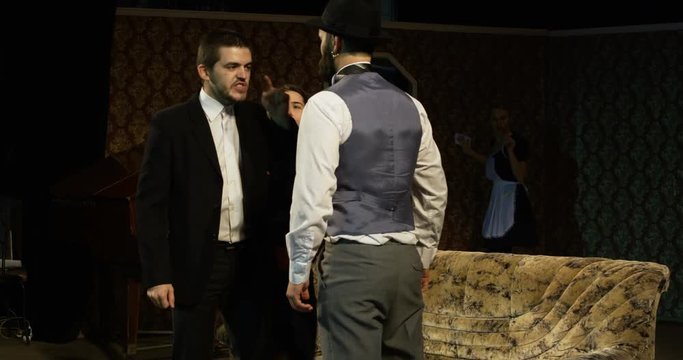 Medium shot of actors performing a scene where a woman mediating between two quarreling men